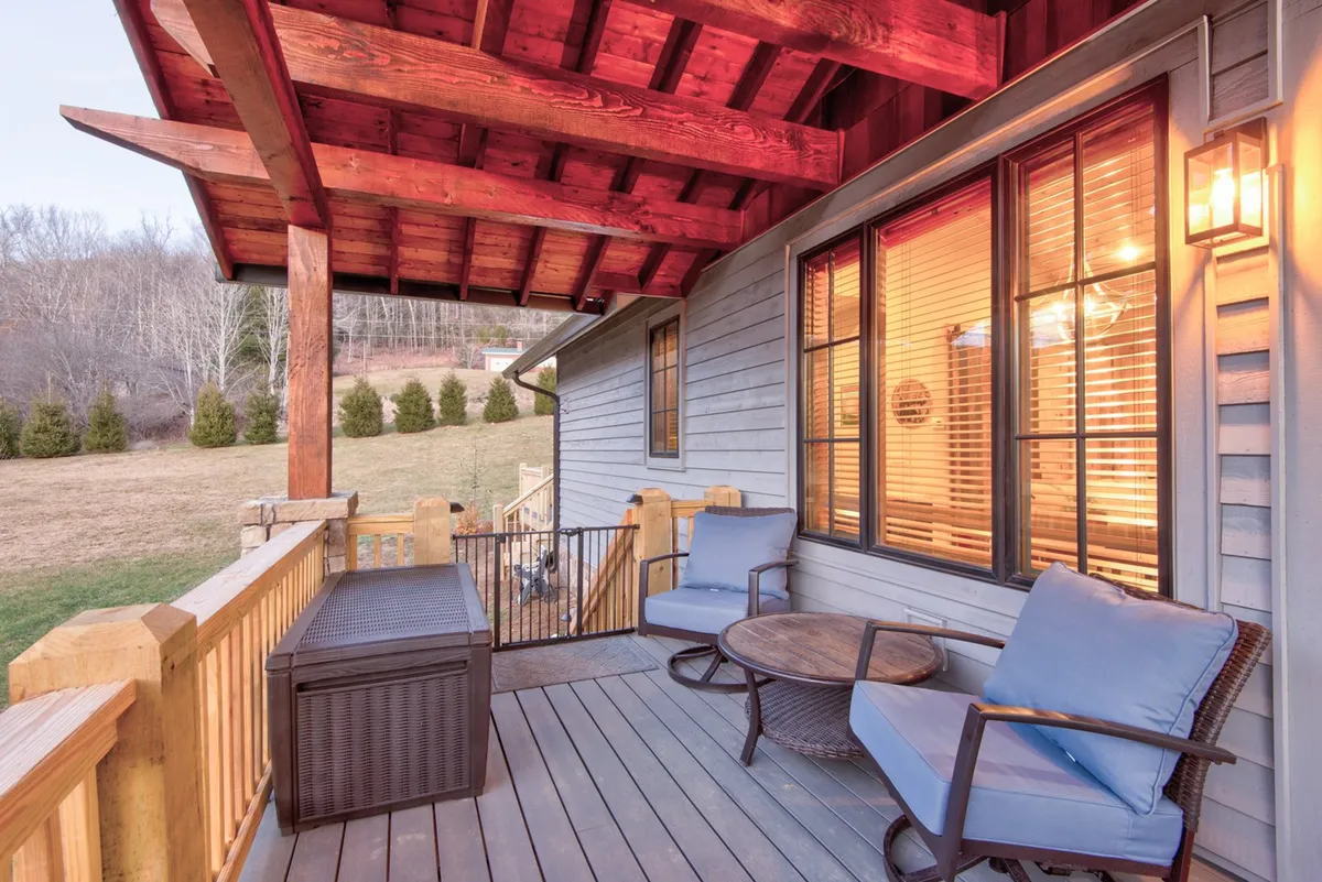 This image showcases a comfortable outdoor seating area framed by wooden beams and natural landscape. The scene is bathed in morning sunlight, echoing the tranquility and beauty of the surrounding High Country environment.
