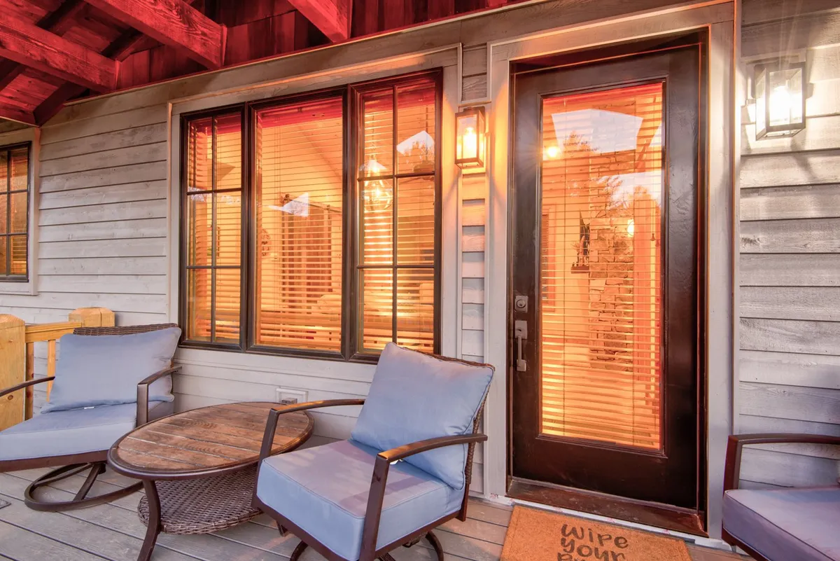 This exterior image highlights the welcoming entrance to the property, featuring inviting outdoor seating and decorative lighting. The setting suggests a relaxed environment where guests and their pets can unwind after a day of adventure.